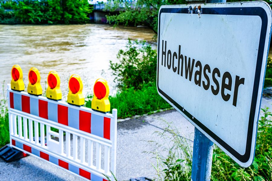 Hochwasserschild vor gesperrtem Uferweg